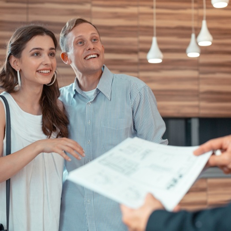 Looking at realtor. Couple looking at realtor giving them the documents before buying house